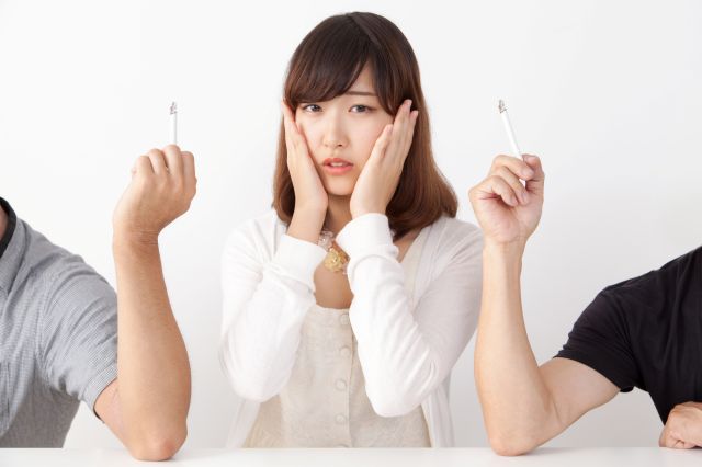 喫煙者にはさまれて困る女性